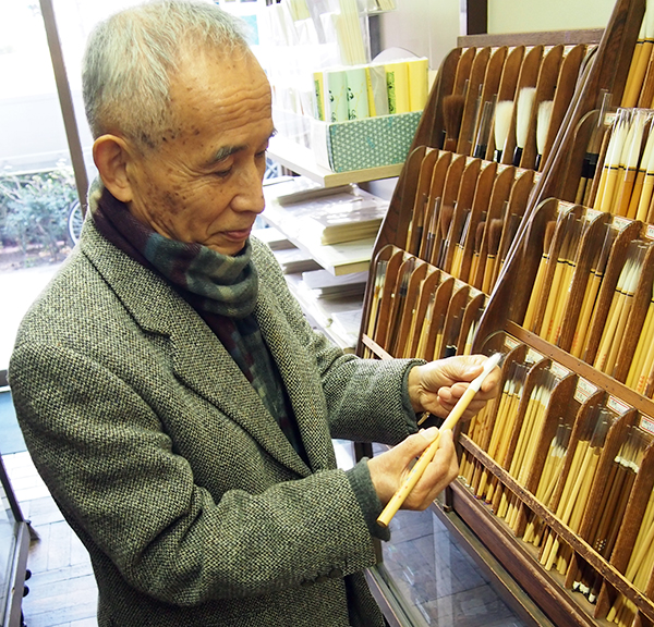 筆の説明をする店主